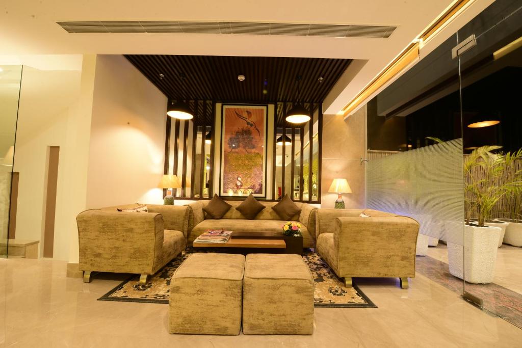 a living room with a couch and two chairs at SureStay Plus Hotel by Best Western Amritsar in Amritsar