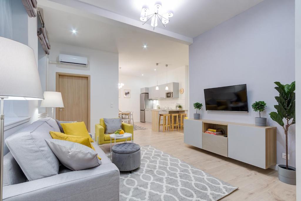 ein Wohnzimmer mit einem Sofa und einem TV in der Unterkunft Rózsa Apartments in Budapest