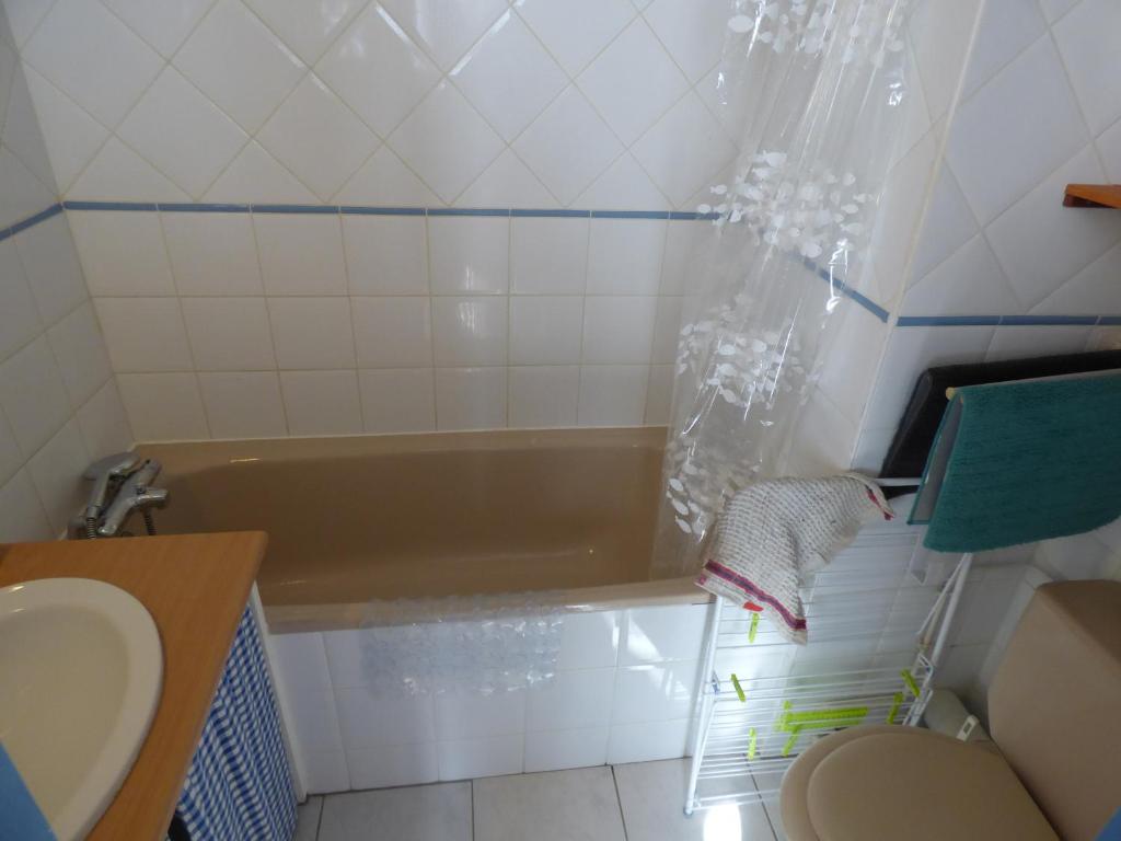 a bathroom with a tub and a toilet and a sink at Appartement de la cascade in Eaux-Bonnes