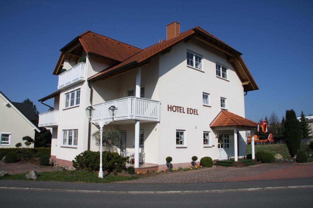 ein weißes Hotelgebäude mit rotem Dach in der Unterkunft Hotel Edel in Haibach