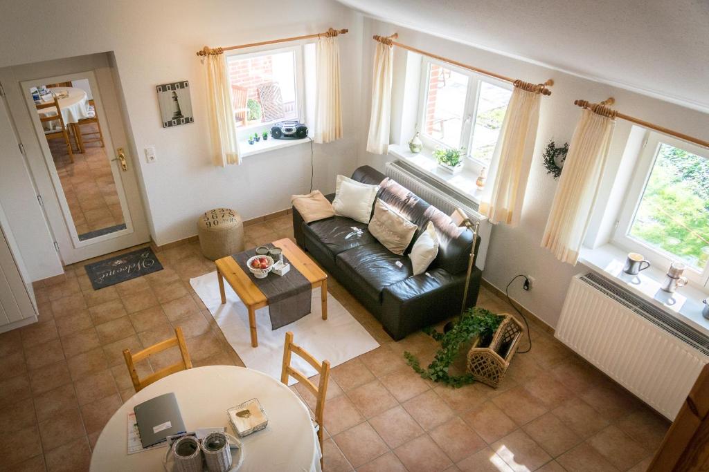 ein Wohnzimmer mit einem Sofa und einem Tisch in der Unterkunft Eichenhof III in Grothusenkoog