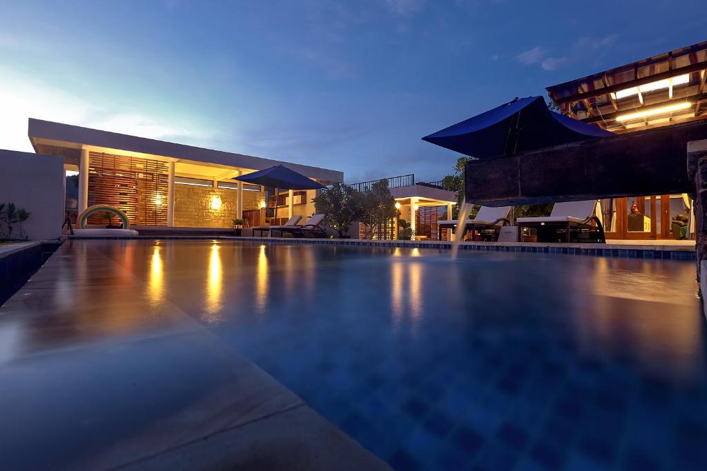 een zwembad voor een gebouw 's nachts bij Villa Luna Kuta Lombok in Kuta Lombok