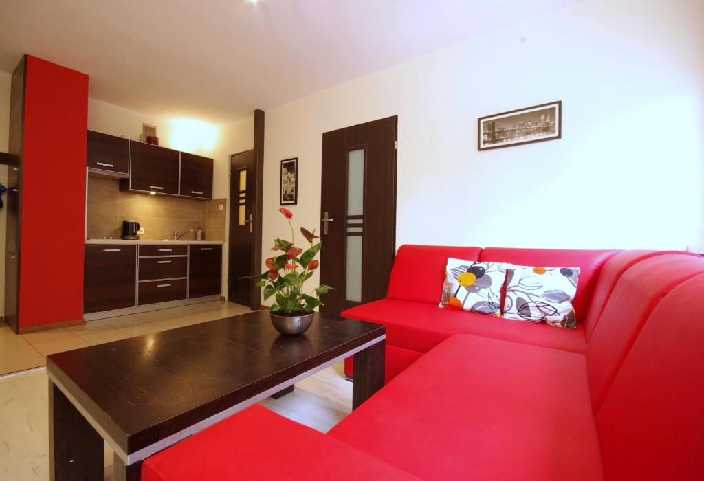 a living room with a red couch and a table at Apartament Efekt in Wrocław
