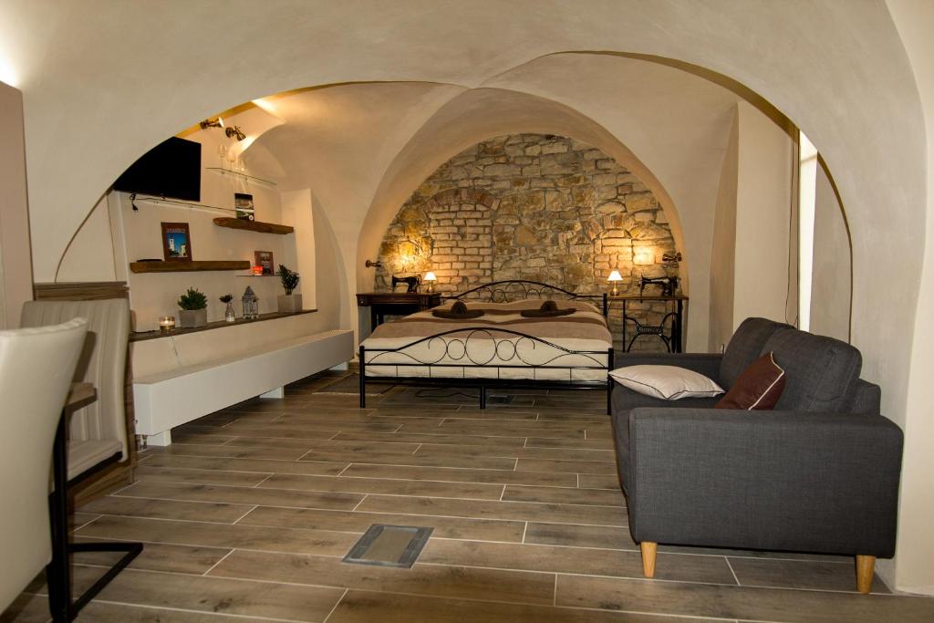 ein Schlafzimmer mit einem Bett und einem Sofa in einem Zimmer in der Unterkunft Apartmán U Gotického dvojčete in Leitmeritz