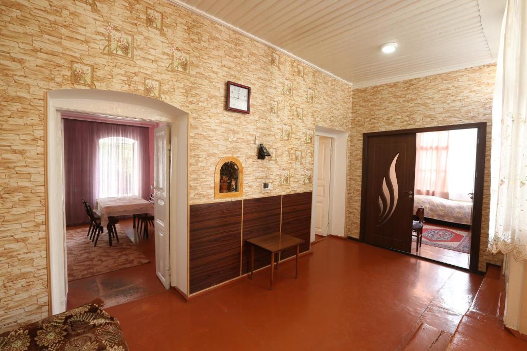 een woonkamer met een bakstenen muur en een tafel bij Guesthouse ''Ashot Shalunts'' in Goris