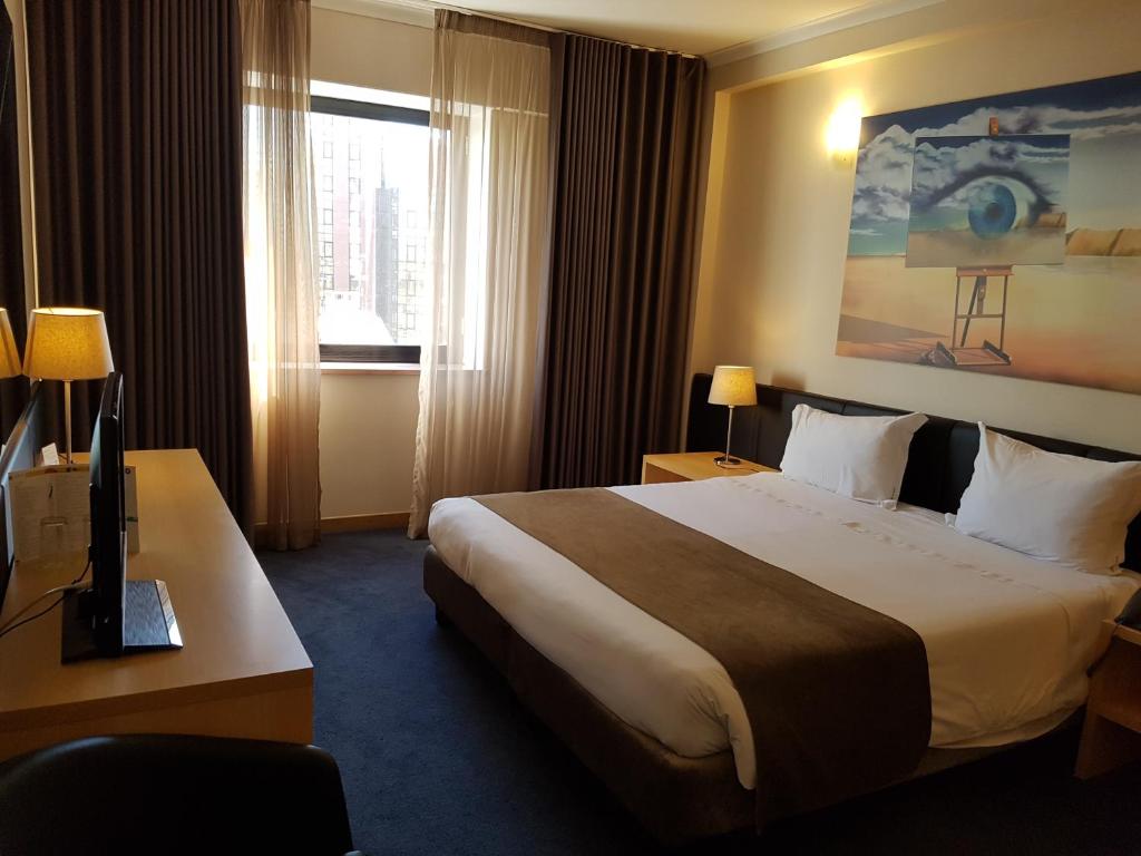 Hotel 3K Barcelona: Spacious and modern hotel room with a large bed, tasteful artwork, and ample natural light from the window/