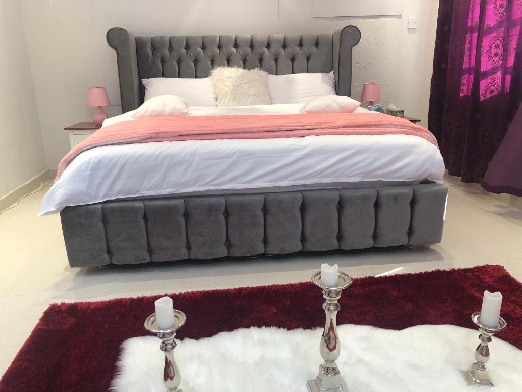 una camera da letto con un grande letto con due candele sul pavimento di Tafadal a Ibrā