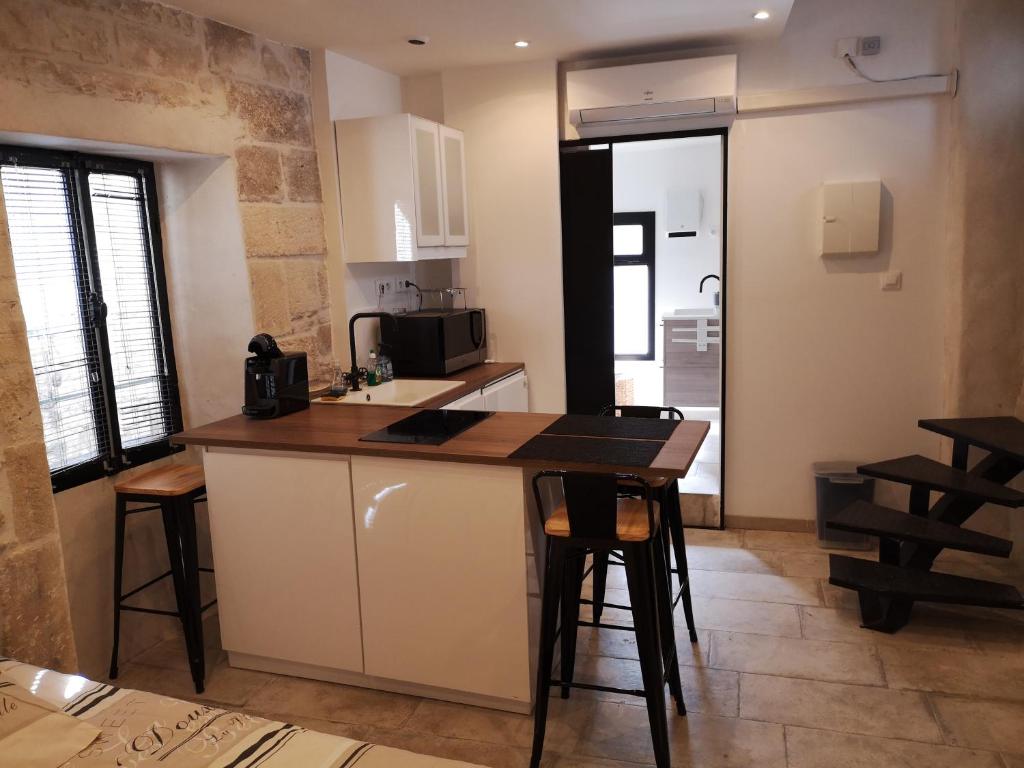 a kitchen with a counter and a table and chairs at Maison de naissance de Nostradamus in Saint-Rémy-de-Provence