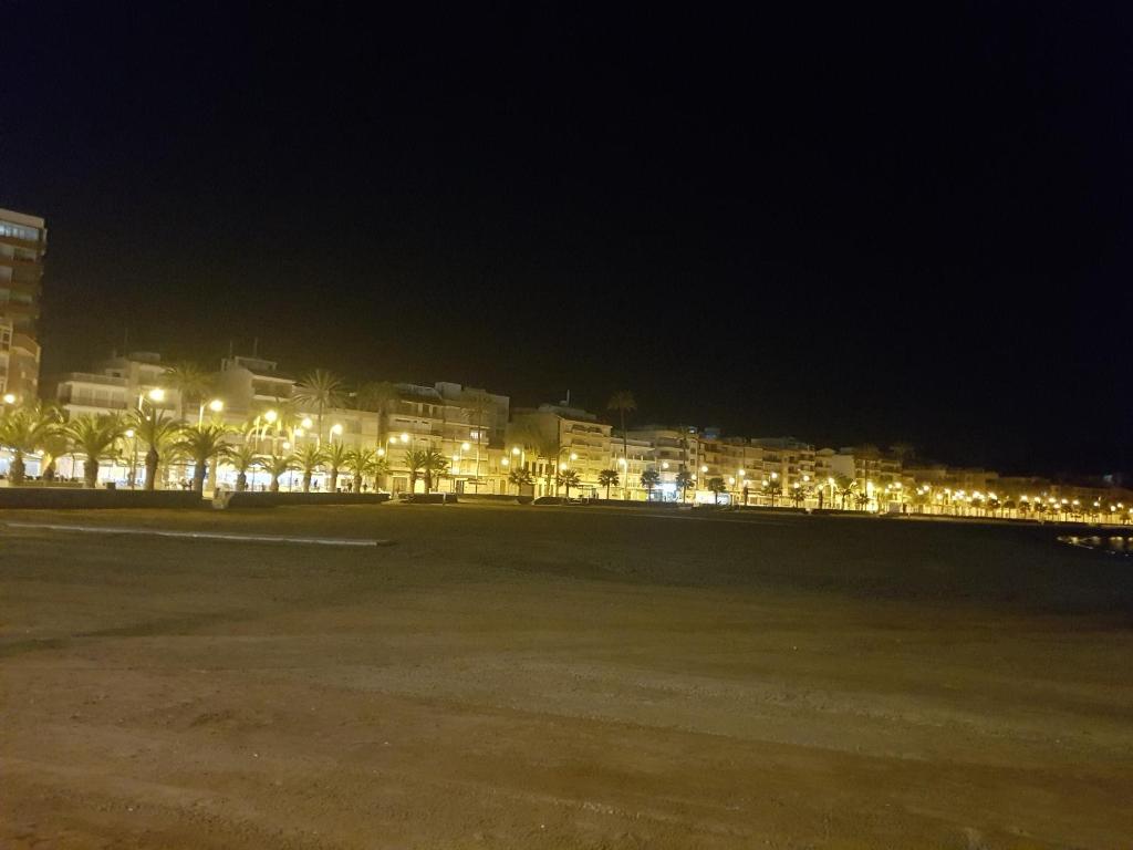 a city at night with lights on the beach at La Linea in Puerto de Mazarrón