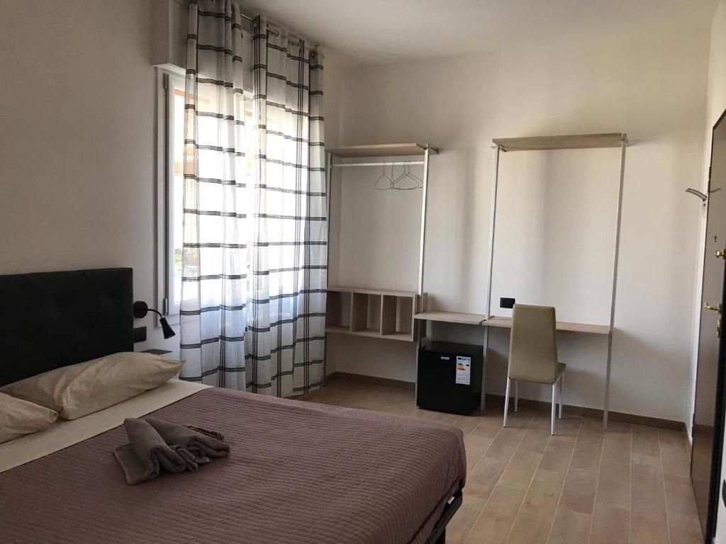 Schlafzimmer mit einem Bett, einem Schreibtisch und einem Stuhl in der Unterkunft Riva Reno 4 Rooms in Bologna