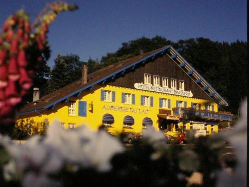 a yellow building with a sign on top of it at Auberge du Lac in Xonrupt-Longemer