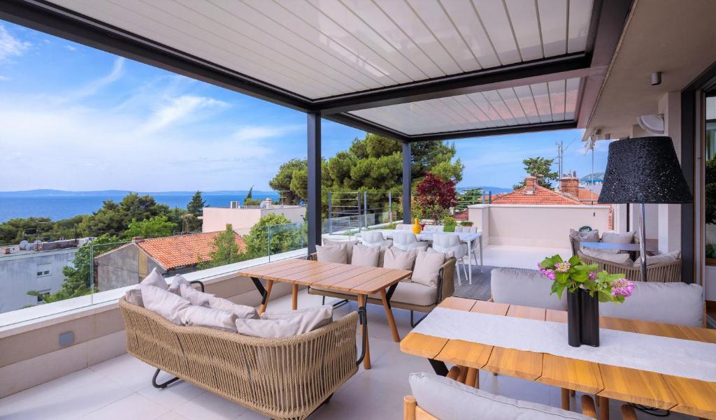 een patio met een tafel en stoelen op een balkon bij Alba Residence in Split