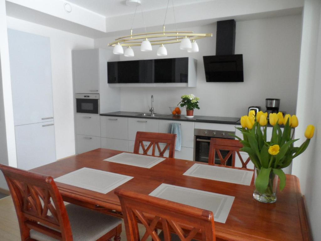 a kitchen with a dining room table with yellow tulips at Staapli apartment in Tallinn