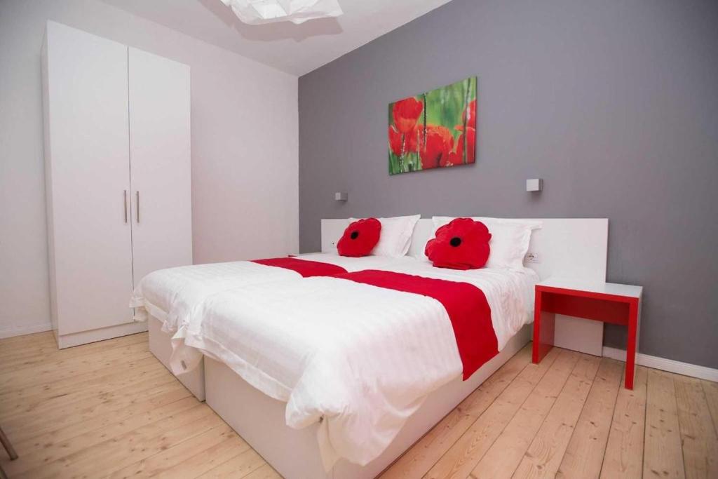 a bedroom with a large bed with two red teddy bears on it at Hotel Rimini Tirana in Tirana