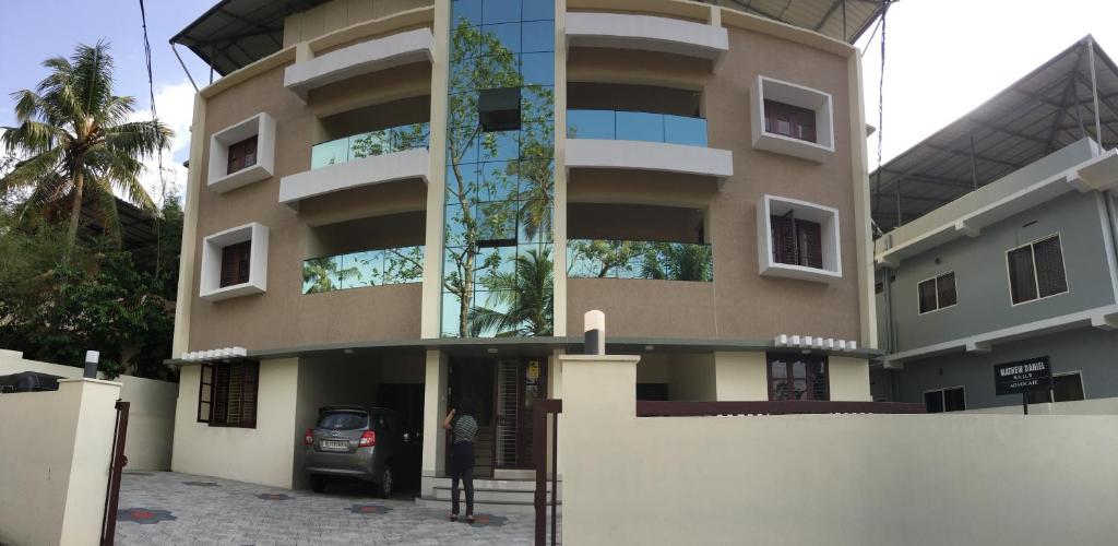 ein Gebäude mit einem davor geparkt in der Unterkunft Athrakkattu Enclave in Thiruvananthapuram