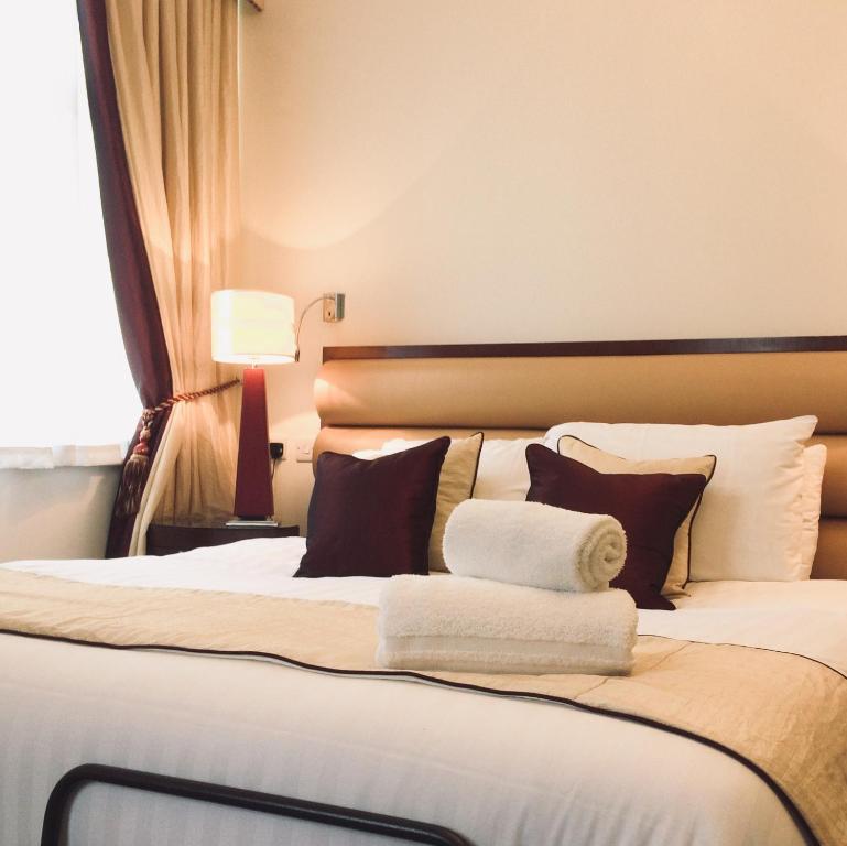 a hotel room with a large bed with towels on it at Kings Park Hotel in Retford