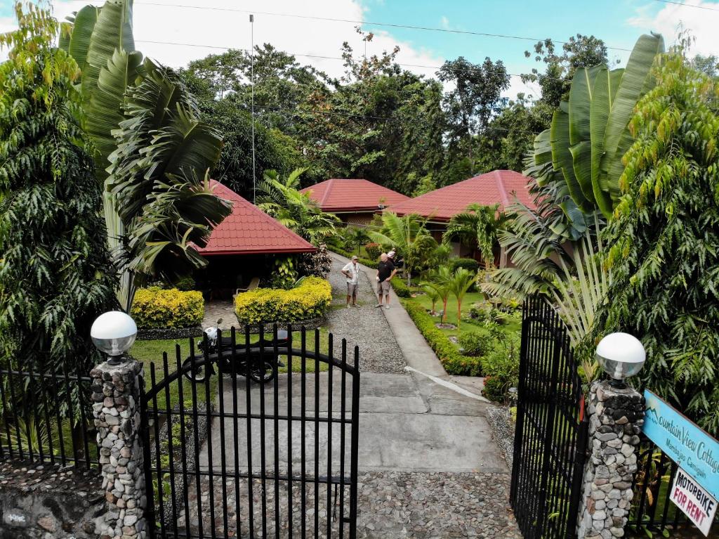 um portão em frente a uma casa com jardim em Mountain View Cottages em Mambajao