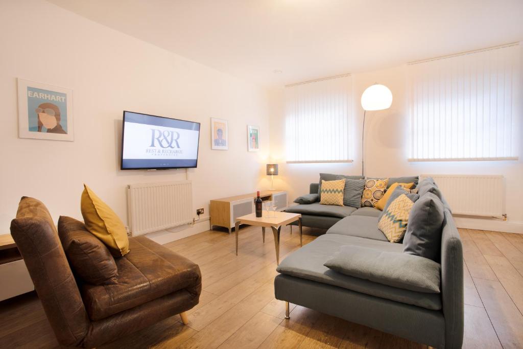 a living room with two couches and a flat screen tv at Rest & Recharge in the Northern Quarter in Manchester