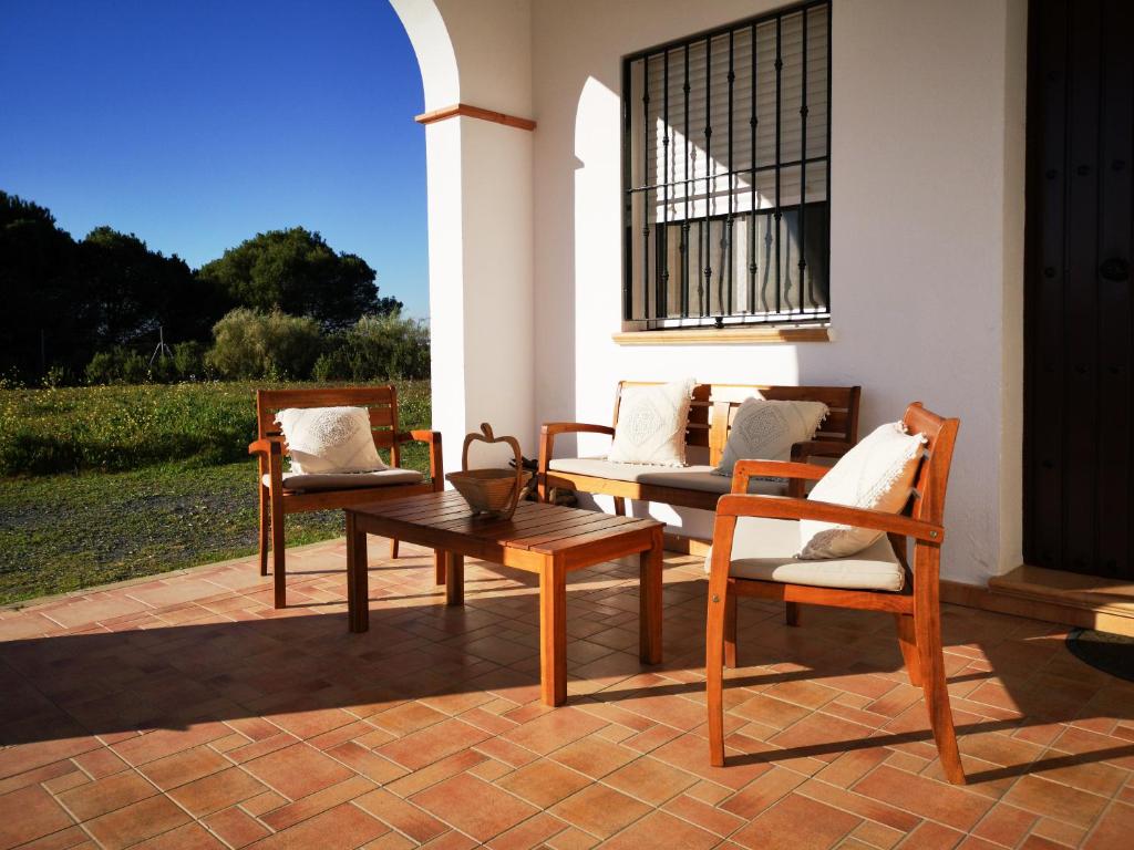 grupa krzeseł i stół na patio w obiekcie Casa Rural Cerca de la Playa El Rompido w mieście El Rompido