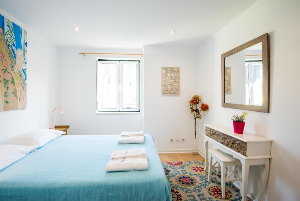sypialnia z łóżkiem, biurkiem i lustrem w obiekcie Madragoa Hideout w Lizbonie