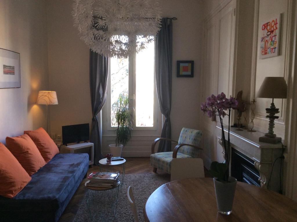 uma sala de estar com um sofá azul e uma mesa em le gambetta em Lyon