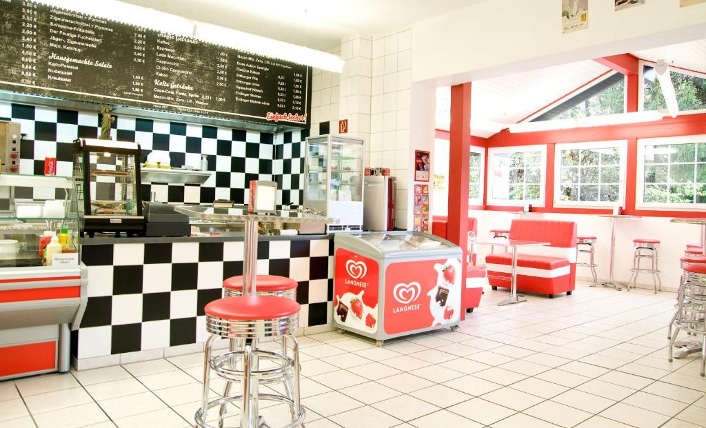 a fast food restaurant with red stools in a diner at Zum Fuchsbau in Niederhövels