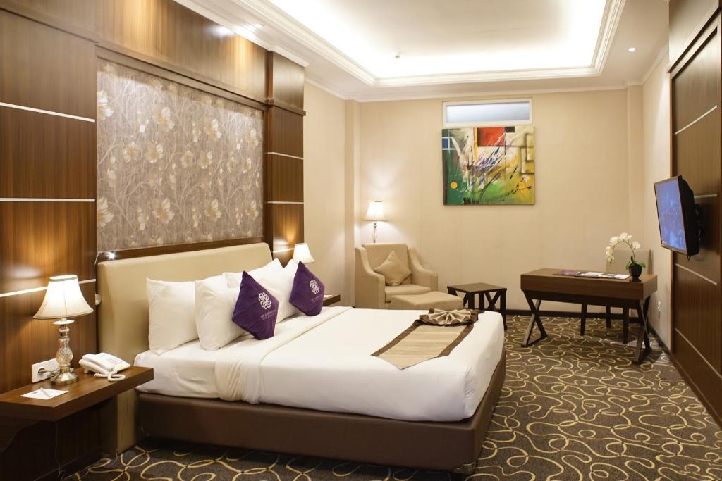 Postel nebo postele na pokoji v ubytování Adhiwangsa Hotel