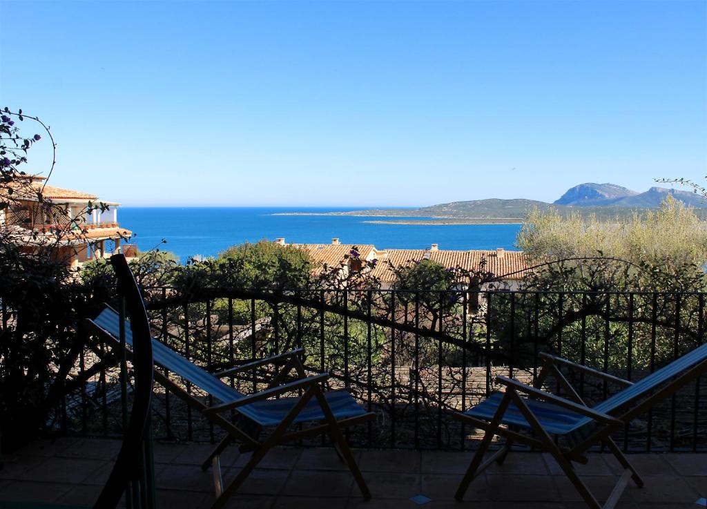 zwei Stühle auf einer Terrasse mit Meerblick im Hintergrund in der Unterkunft Casa vacanze il Corbezzolo - Golfo di Marinella in Porto Rotondo