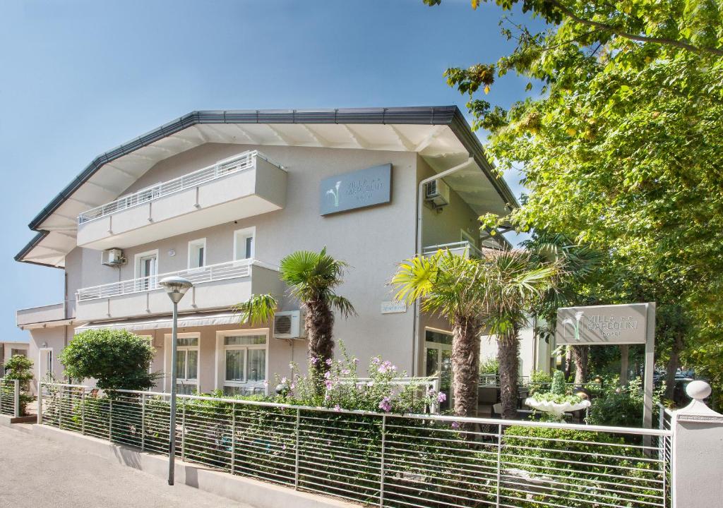 a white building with trees in front of it at Villa Marcolini in Cattolica