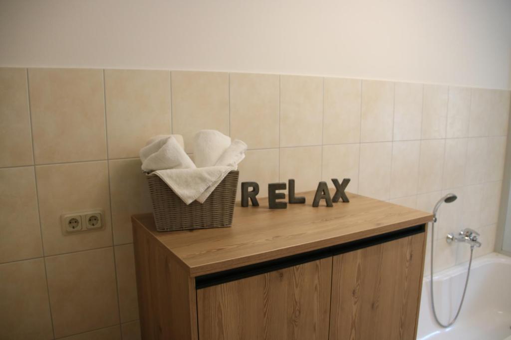 a bathroom with a sink and a tub and a basket of towels at Heilotel in Heilbad Heiligenstadt