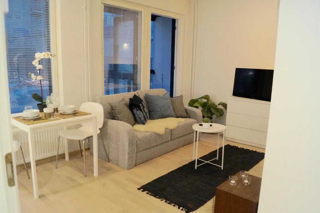 a living room with a couch and a table at Studio in Trendy Kakola Hill area close to city center in Turku