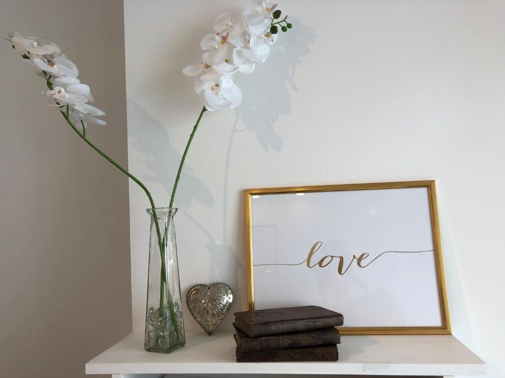 a vase with flowers on a shelf next to a mirror at Appartement Cosy Calme Central-Terrasse Proche Palais in Cannes
