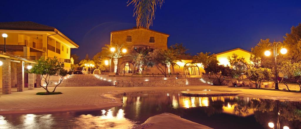 a building with a church and a pond at night at Relais Il Mulino in Corigliano Calabro