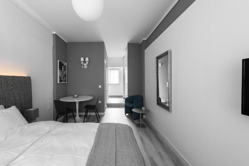 塞薩羅尼基的住宿－M&F Luxury Suites est. 2019 / F Suite，一间卧室配有一张床、一张桌子和一面镜子