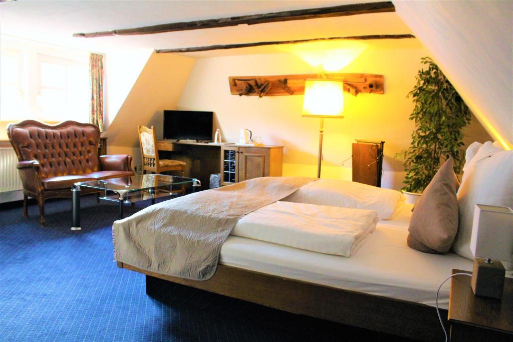 a bedroom with a large bed and a living room at Hotel Ritter St. Georg in Braunschweig