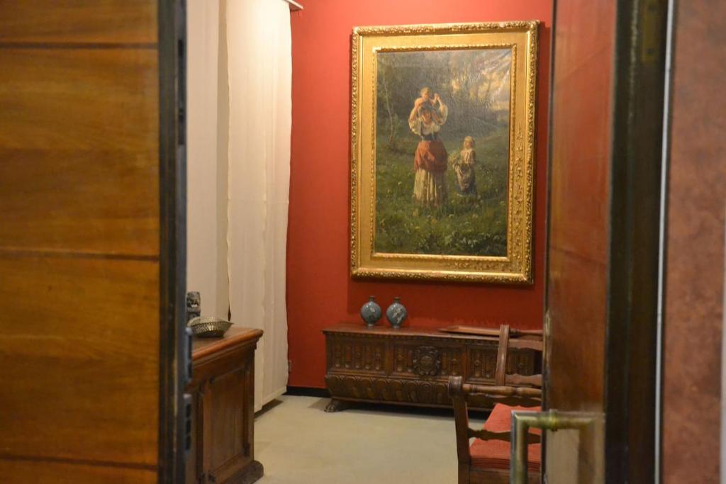 ein Zimmer mit einem Gemälde an der Wand und einem Tisch in der Unterkunft Fieschi Inn in Genua