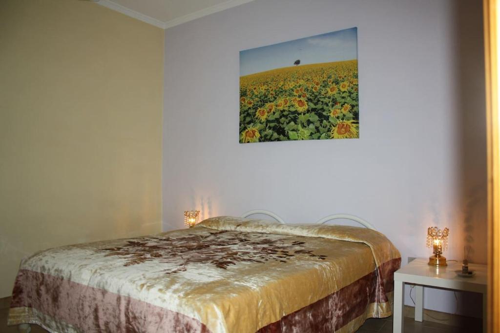 una camera con un letto con una foto di un campo di fiori di Appartamento Vacanze a San Giovanni Rotondo