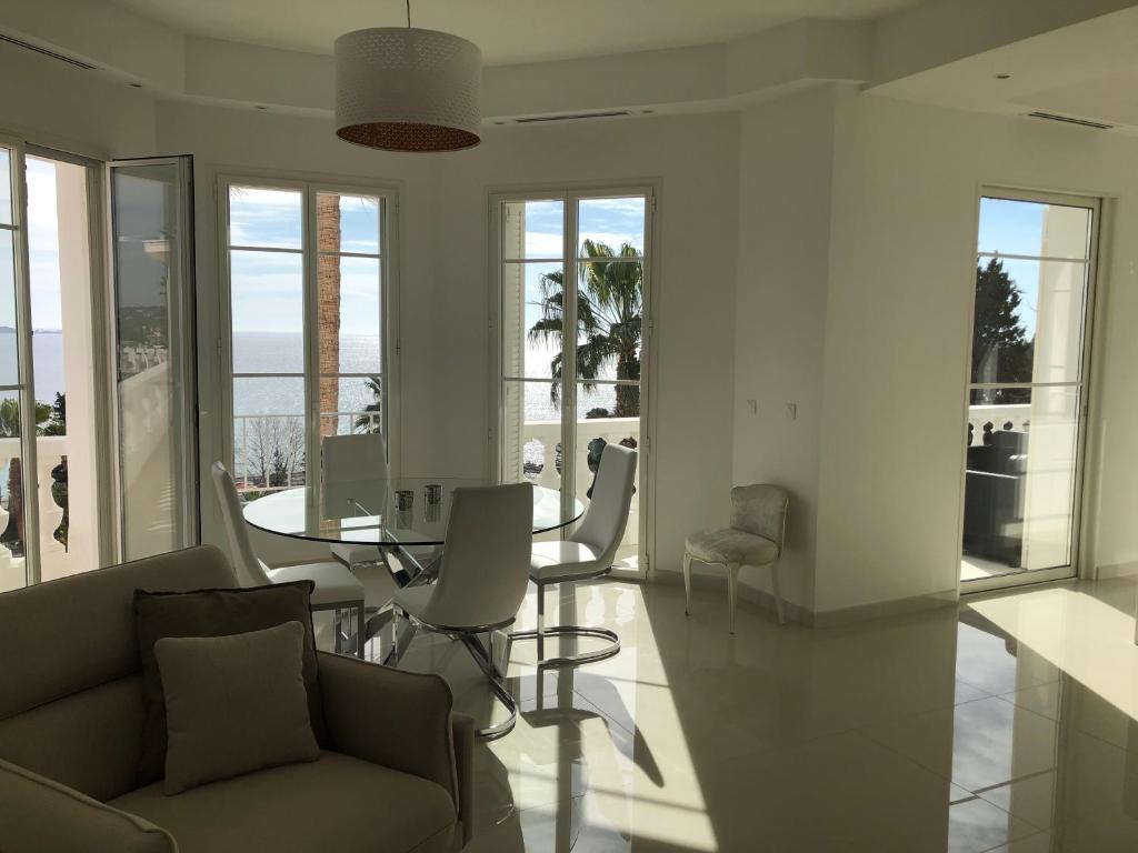 a living room with a couch and a table and chairs at Magnifique Appartement Vue Mer in Vallauris