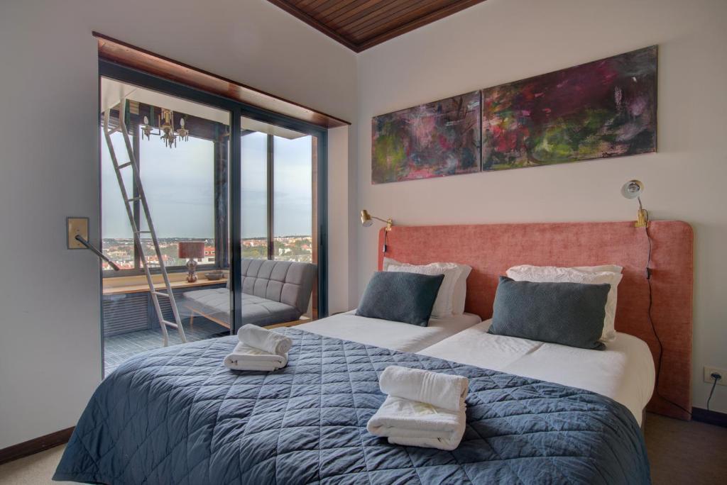 1 dormitorio con 2 camas y ventana grande en Atlantic Views, en Estoril