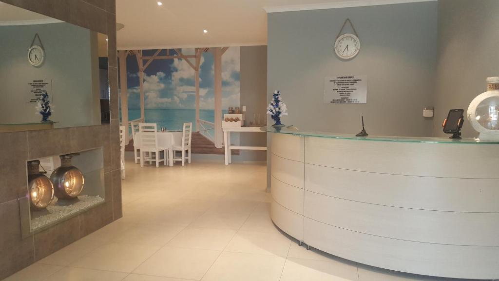 a lobby with a counter with a clock on the wall at Bella Luna Bed and Breakfast in Walvis Bay