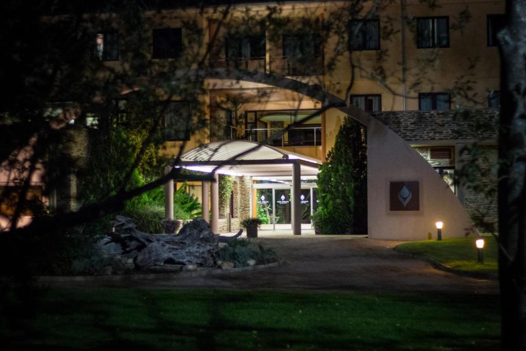 a night view of a building with a lit up entrance at Hotel Balneario Valle del Jerte in Valdastillas