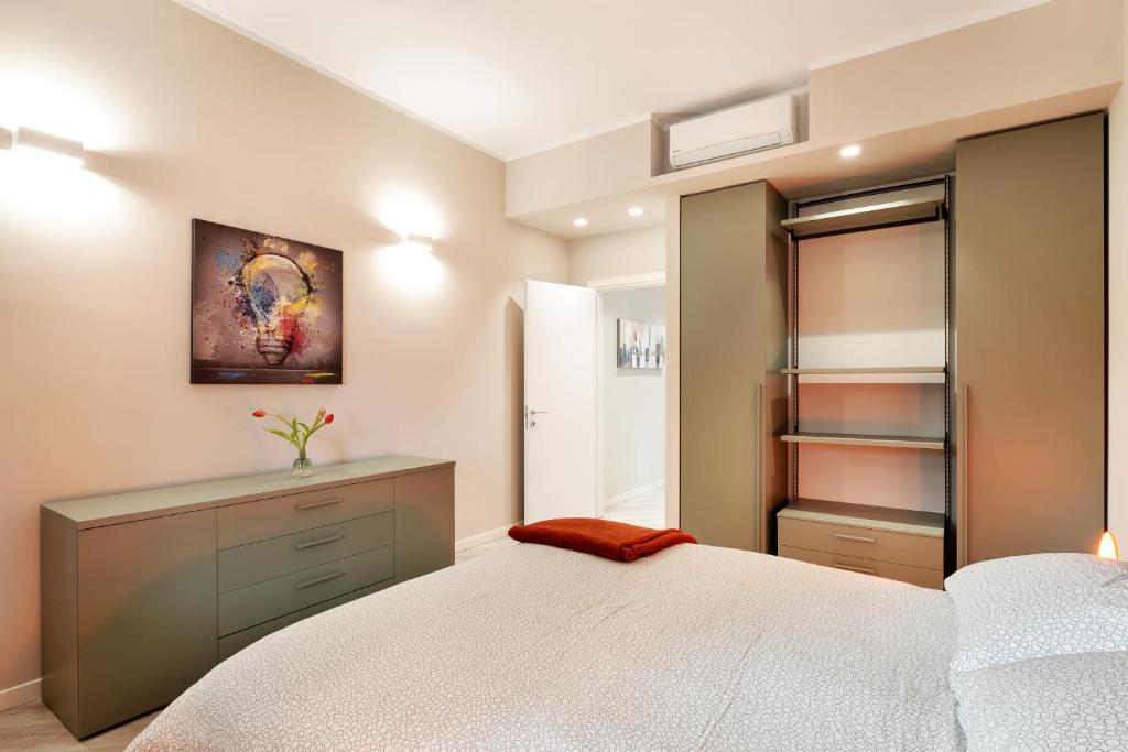 1 dormitorio con cama blanca y vestidor en Maggiore Residence Flats, en Bolonia