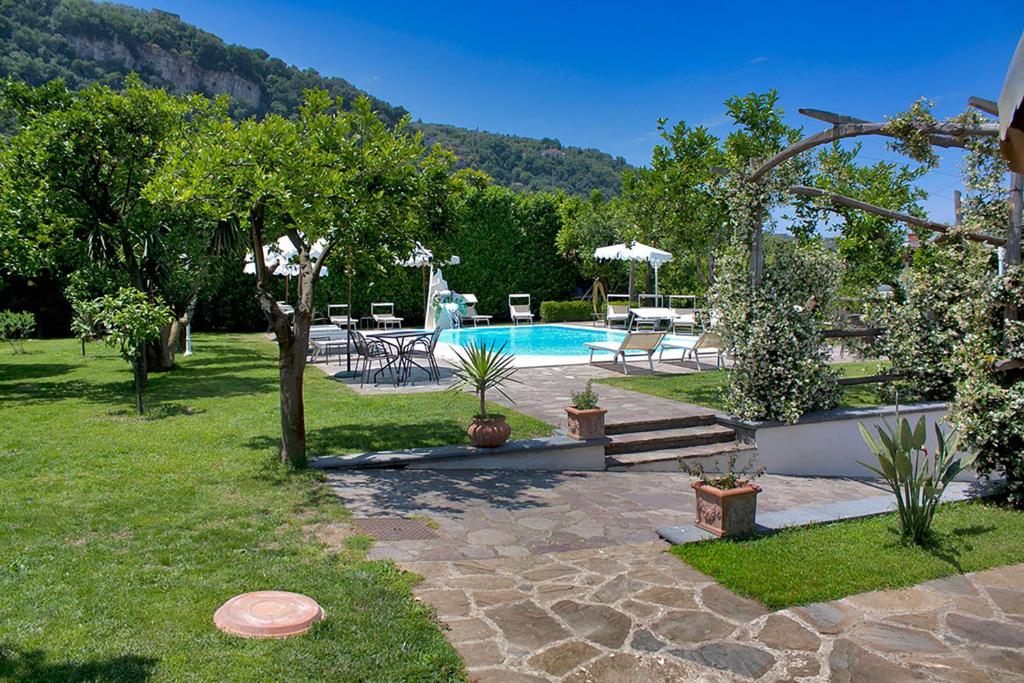 une arrière-cour avec une piscine, une table et des chaises dans l'établissement Amore Rentals - Casa Limoneto, à Sorrente