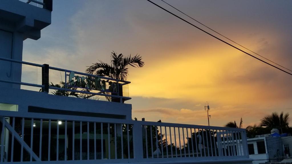 a white fence with a palm tree on top of a building at Casa ka'an in Isla Mujeres