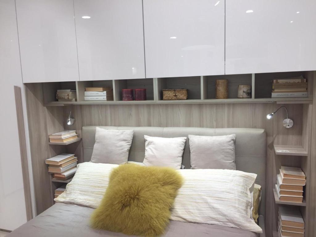 - une chambre avec un lit doté d'un oreiller jaune dans l'établissement Beach Jesolo apartment, à Lido di Jesolo