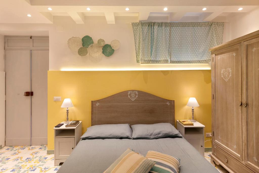 een slaapkamer met een groot bed en 2 nachtkastjes bij I Giardini di Cataldo Sorrento in Sorrento