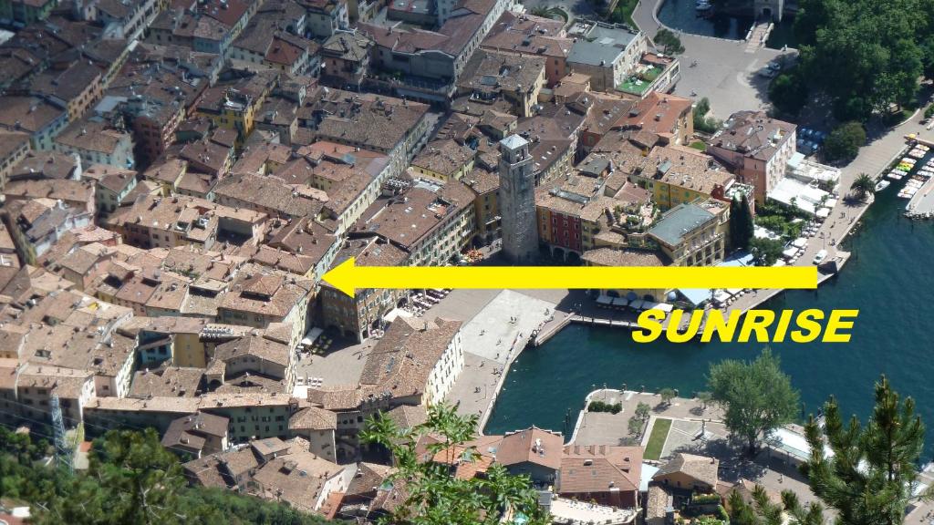 Miasto z żółtą strzałą, która mówi wschód słońca w obiekcie Appartamento Sunrise - Centro Storico N1 w mieście Riva del Garda