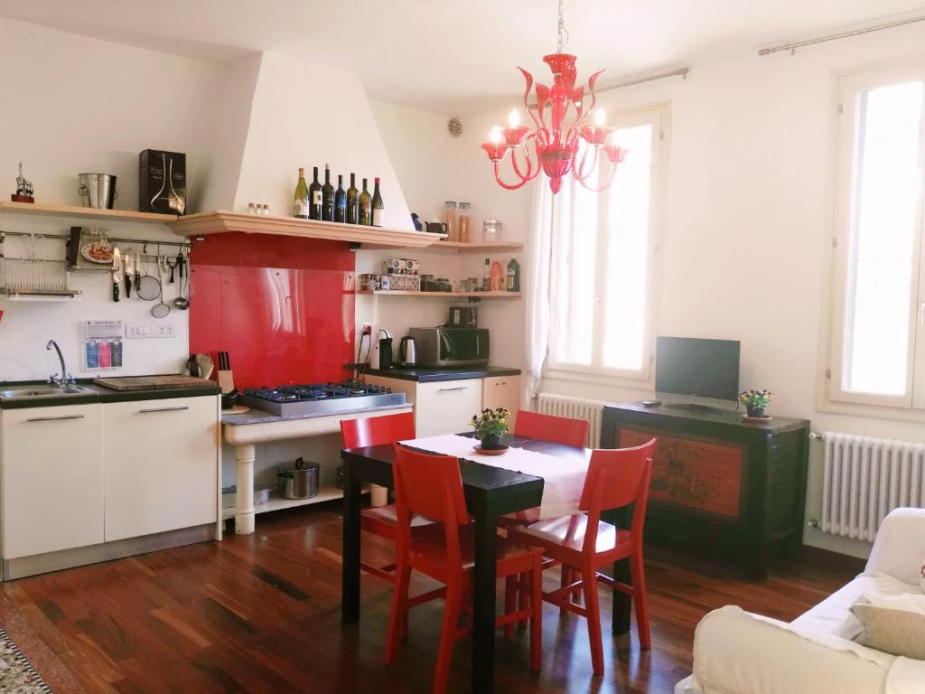 une cuisine avec une table et des chaises rouges dans l'établissement Ponte San Lorenzo apartment, à Venise