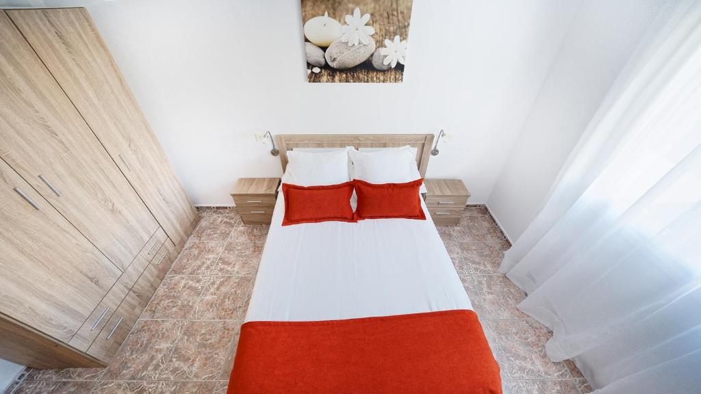 アリナガにあるArmonía Beach 104の小さなベッドルーム(赤い枕のベッド付)