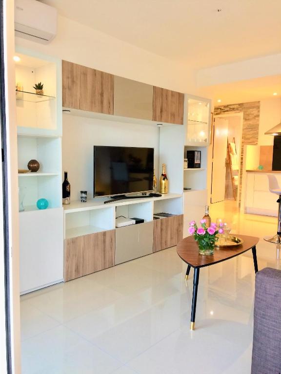 a living room with a television and a table at Appartement Cosy Calme Central-Terrasse Proche Palais in Cannes